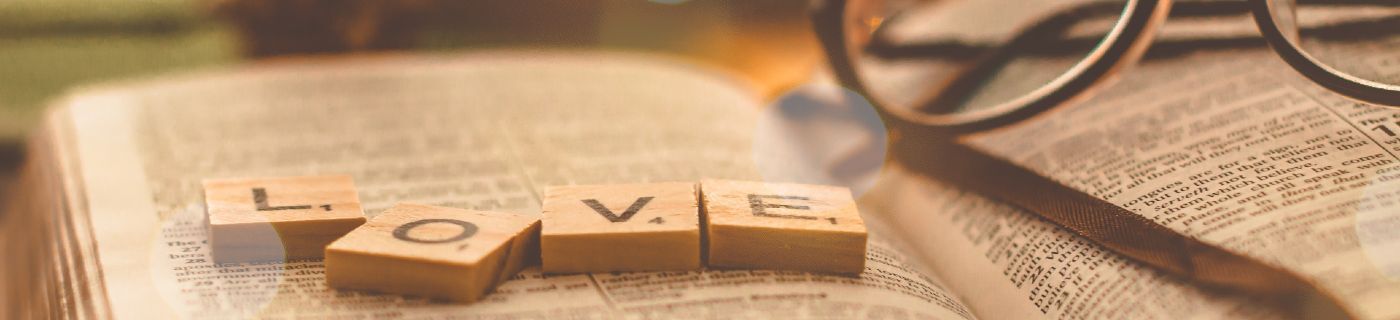 Bible with reading glasses and Scrabble blocks that say love